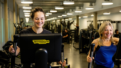 2 ladies on the cross trainers in the gym