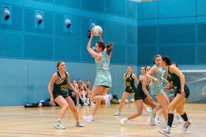Cambridge Female 2 Netball team playing a match in the University Sports Hall